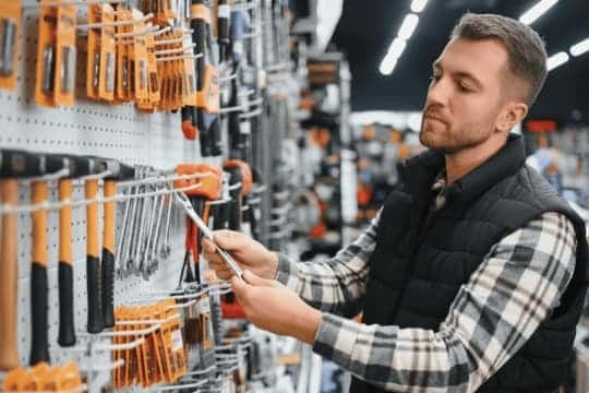 Man shopping for handheld tools at a hardware store supplied by NSJ Wholesale in South Africa